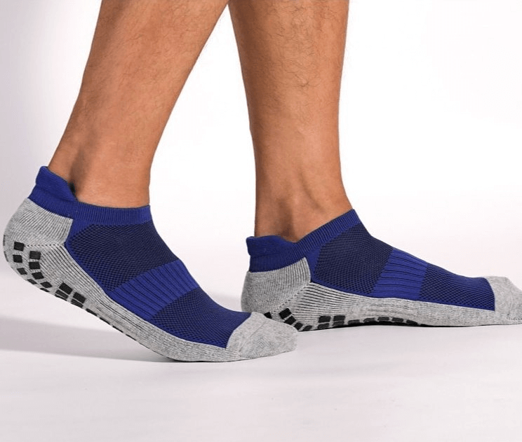 Person wearing blue and gray non-slip sports socks with silicone soles, ideal for unisex football players seeking comfort and grip.